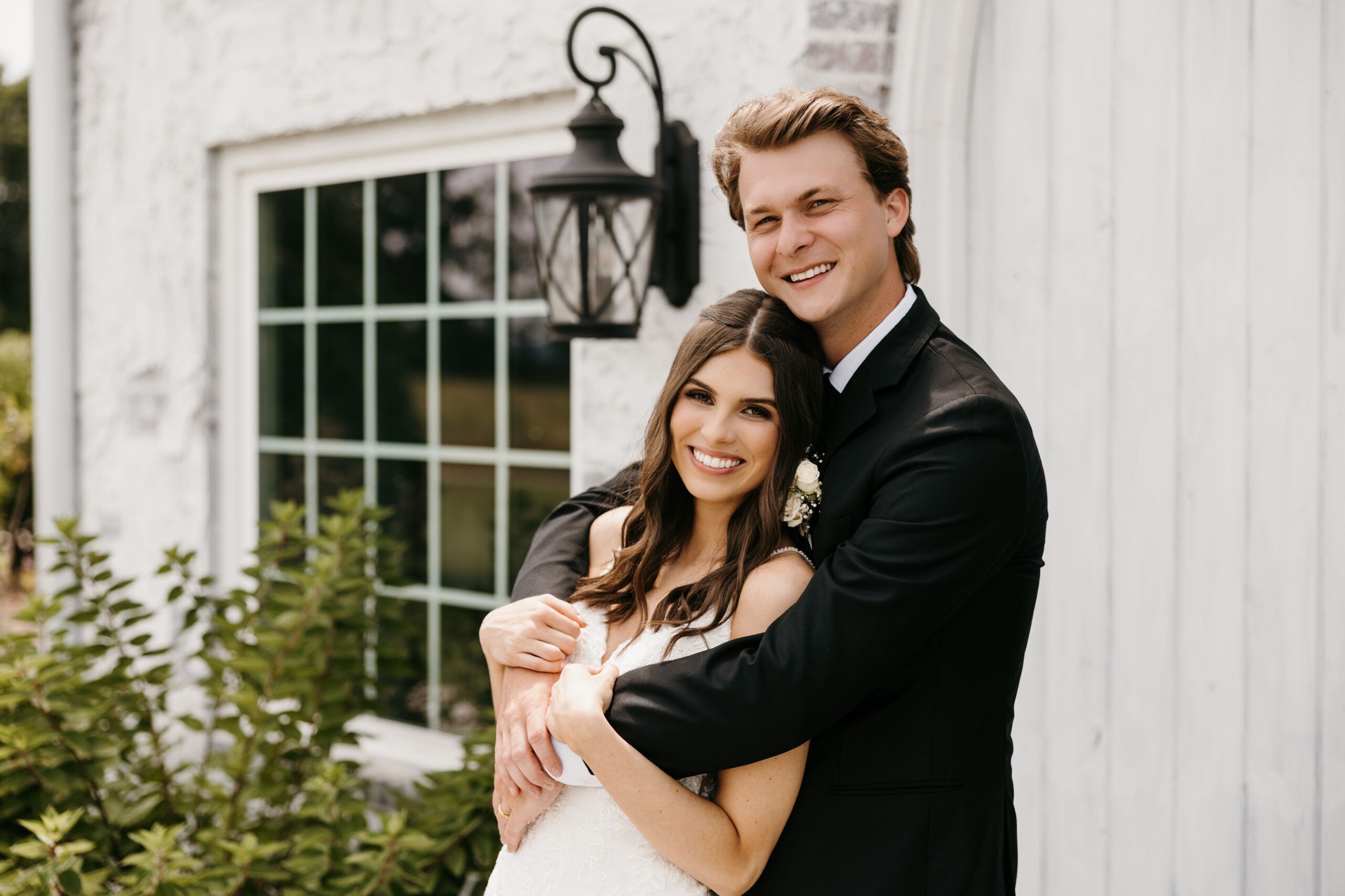 Bride and groom posing with a vintage car at a boutique wedding venue near Chattanooga, showcasing timeless elegance and charm.
